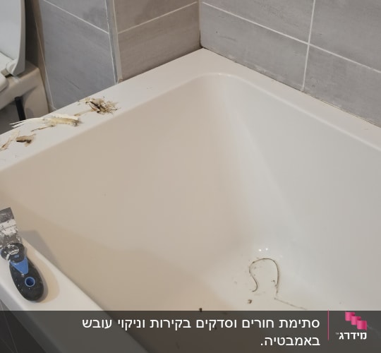 אמבטיה עם לכלוך וכלי עבודה על שפתה